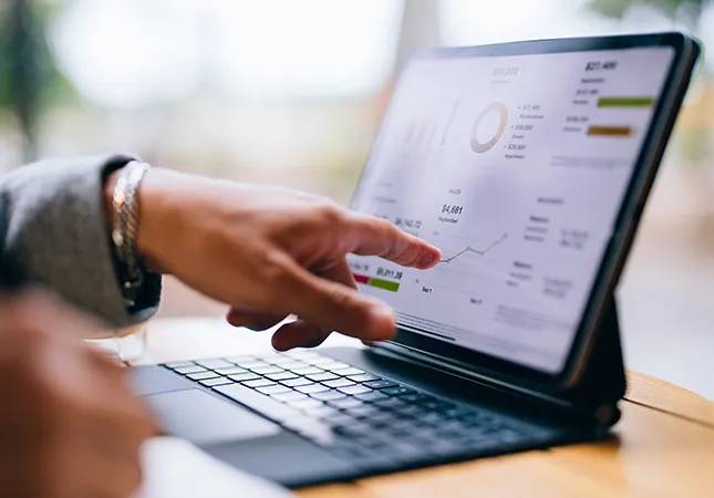 A person pointing at a graph on a tablet computer.