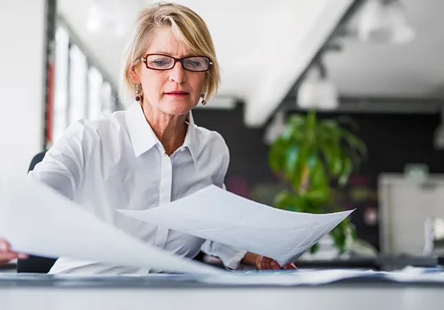 A woman arranging documents on her desk.