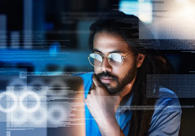 A person looking at a laptop screen with information emerging from the screen.