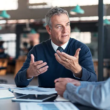 Two men discussing something at a table.