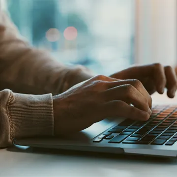 A person typing on a laptop.