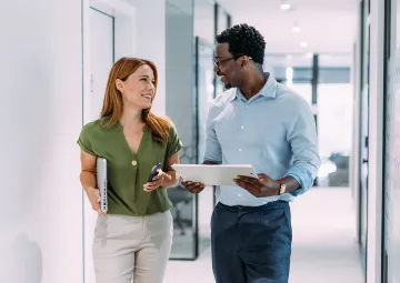 A man and a woman talking in a hallway.