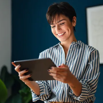 A woman looking at a tablet computer.